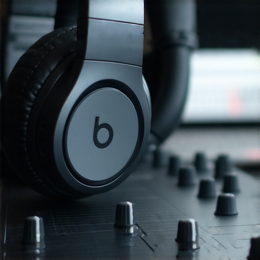 Beats耳機的特寫，展現流線型設計及舒適耳墊，旁邊有專業音樂人專注創作，象徵高音質和專業表現，揭示為何Beats耳機受到音樂人的喜愛。